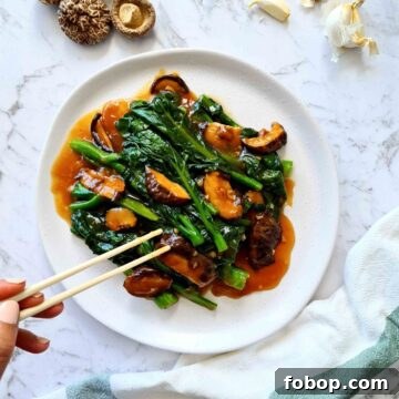 Plate of Chinese broccoli with mushrooms and sauce