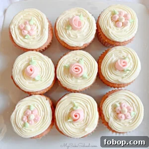 Moist Strawberry Cupcakes with Fresh Strawberry Frosting 12 Closeup of 9 frosted strawberry cupcakes, topped with simple buttercream flowers and ribbon roses.
