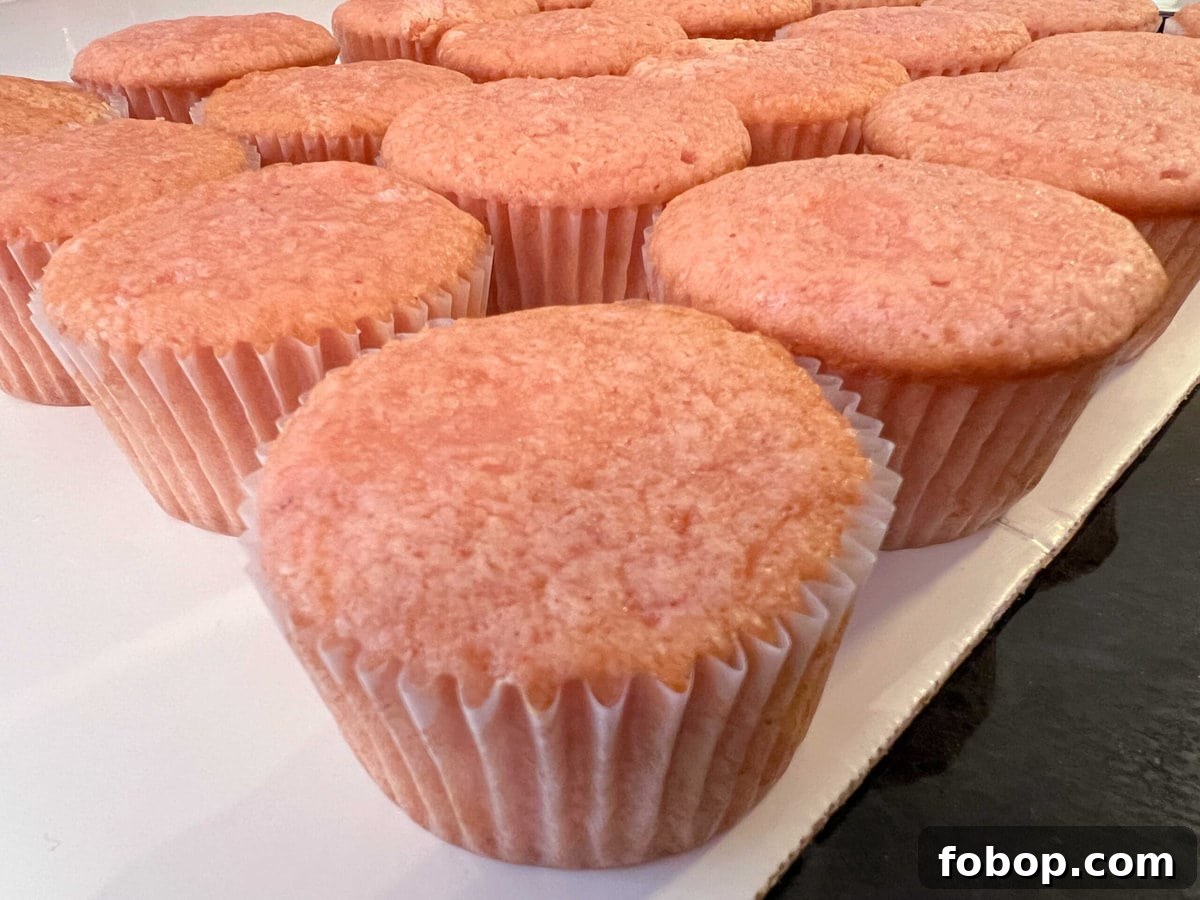 Moist Strawberry Cupcakes with Fresh Strawberry Frosting 5 Freshly baked cupcakes on a cake board.