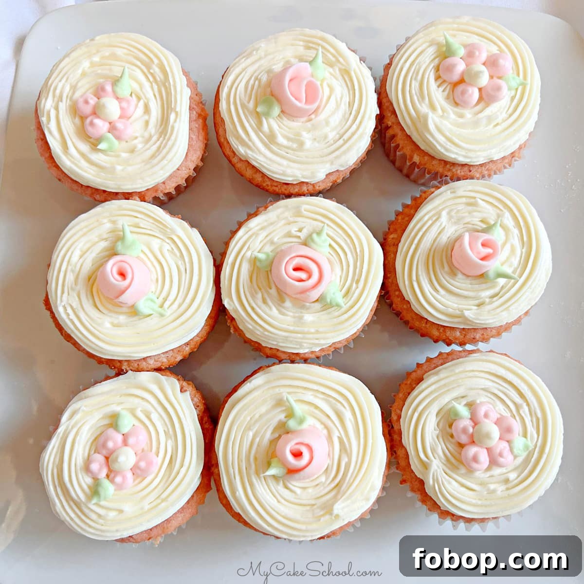Moist Strawberry Cupcakes with Fresh Strawberry Frosting 7 Closeup of 9 frosted strawberry cupcakes, topped with simple buttercream flowers and ribbon roses.