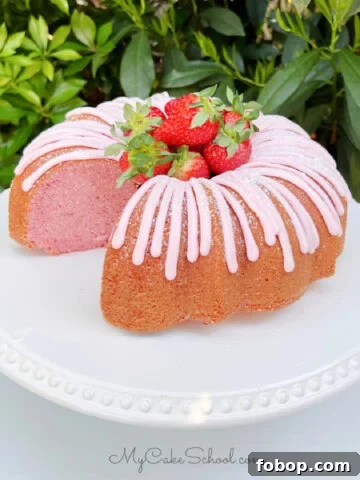 Sliced Strawberry Bundt Cake on White Pedestal.