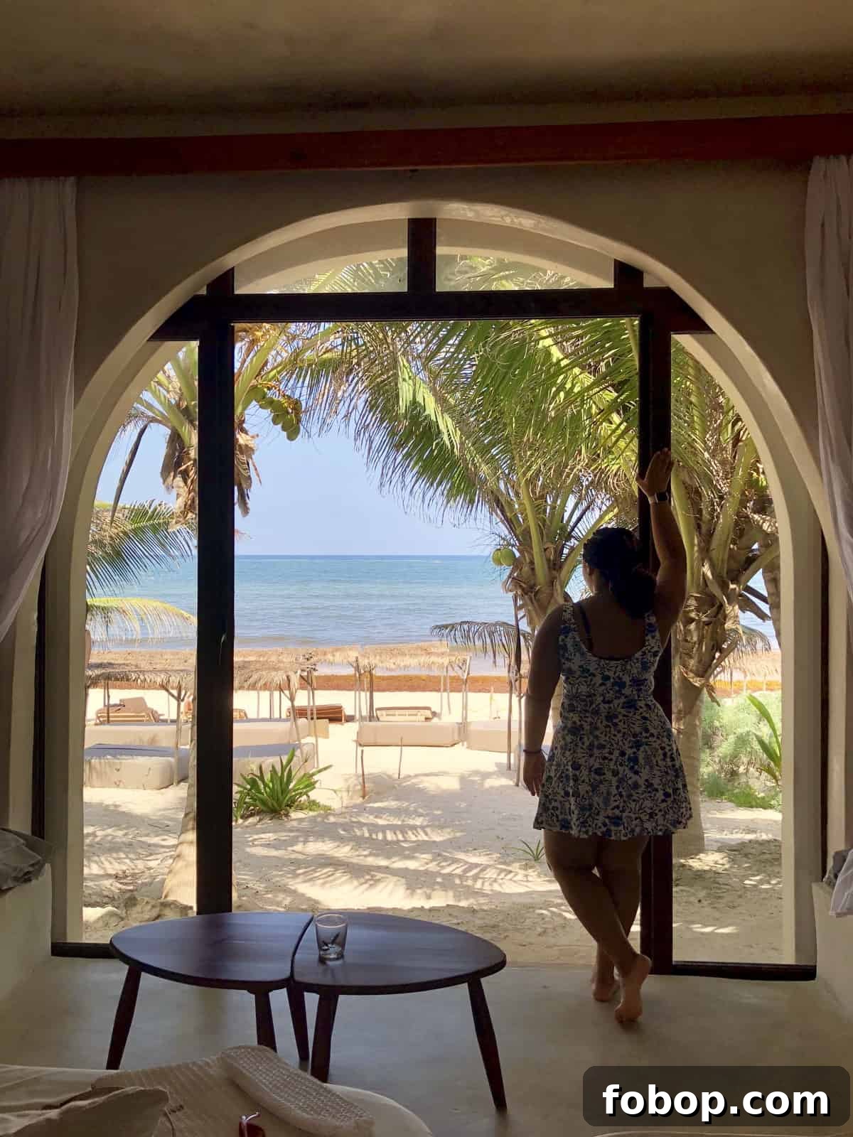 Tulum Travel Guide: Top Eats, Hotels, and Must-See Activities 6 Jessica looking out from hotel room onto a beach.