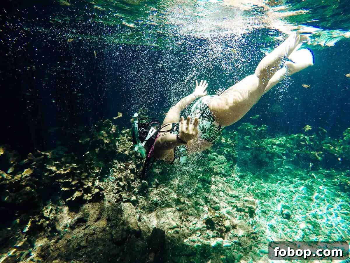 Tulum Travel Guide: Top Eats, Hotels, and Must-See Activities 7 Jessica swimming underwater, with a snorkel.
