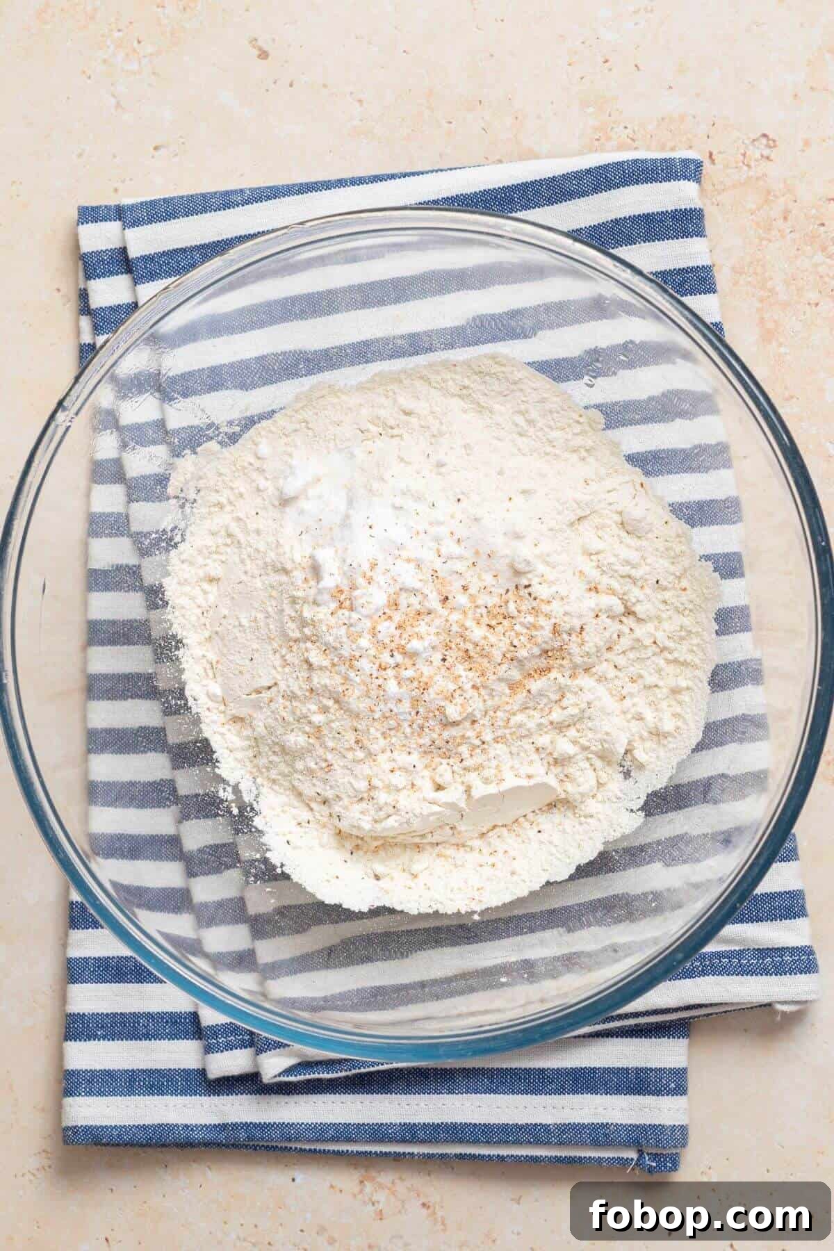 Small-Batch Brown Sugar Cookie Recipe for Perfect Soft Bites 4 A glass bowl with flour in it on top of a striped towel.