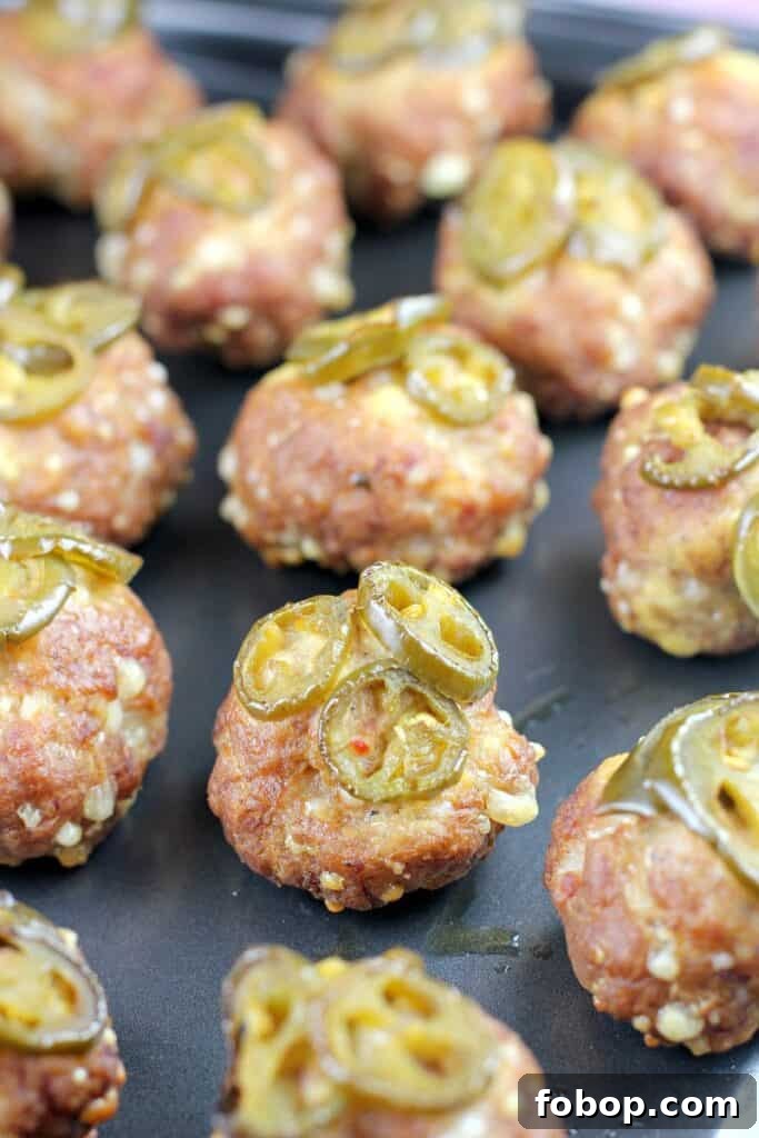 smoked sausage balls topped with jalapenos on metal pan