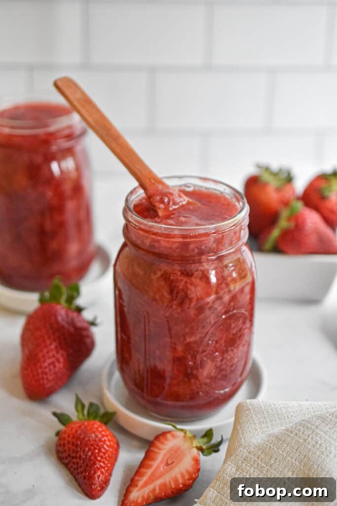 Strawberry jam with a wooden spoon in the mason jar