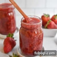 3 Ingredient Instant Pot Strawberry jam with a wooden spoon in the mason jar