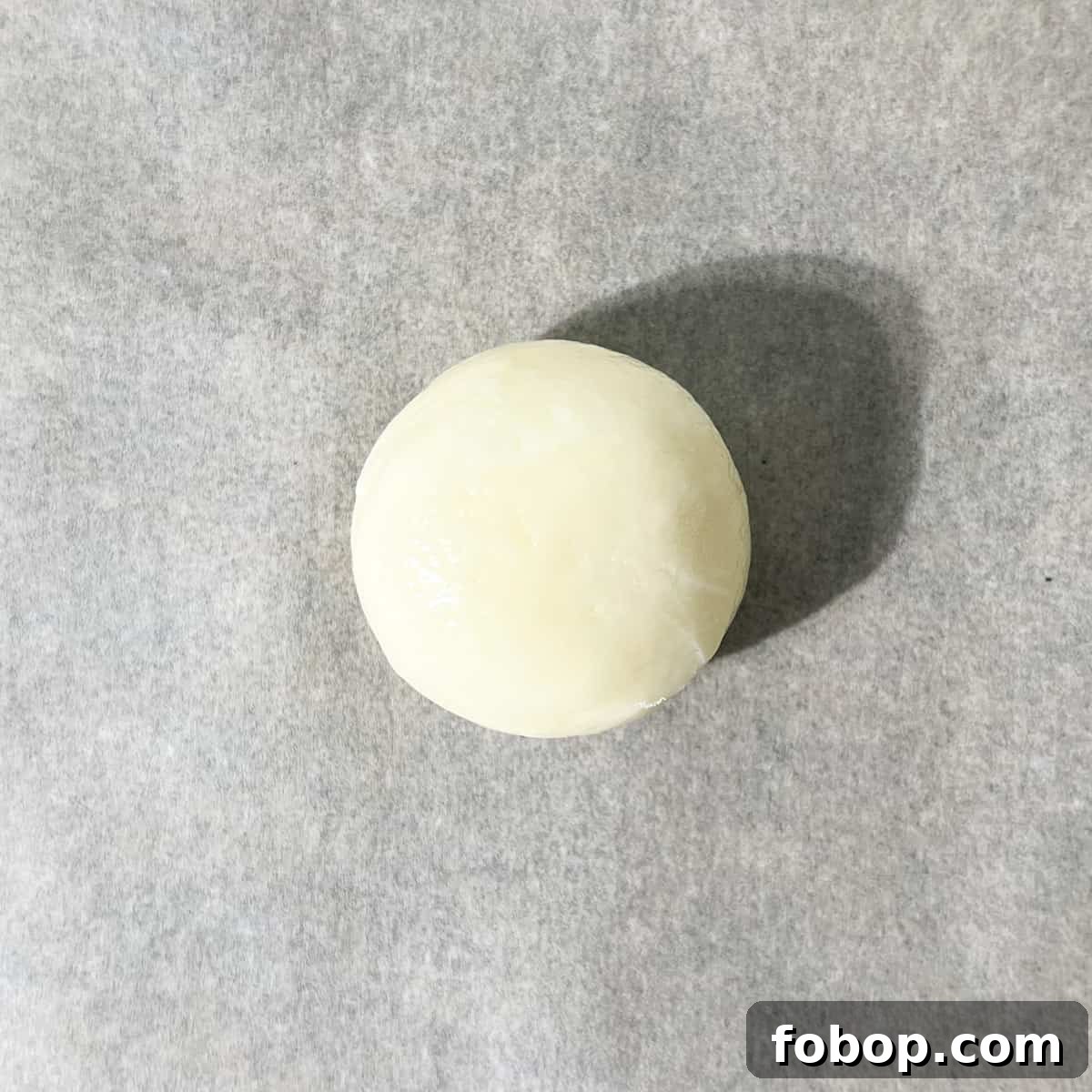 A single dough ball on a baking tray.