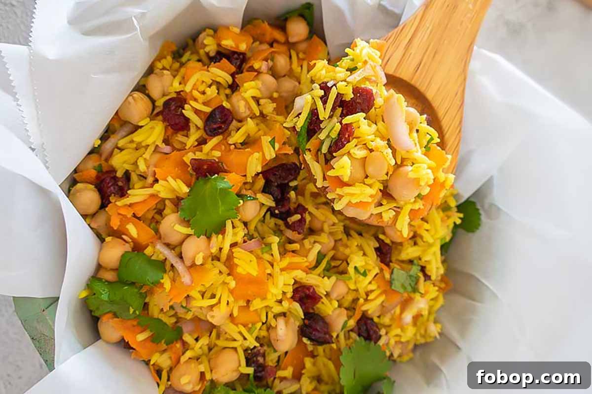 moroccan chickpea rice salad in a bowl with wooden salad spoon