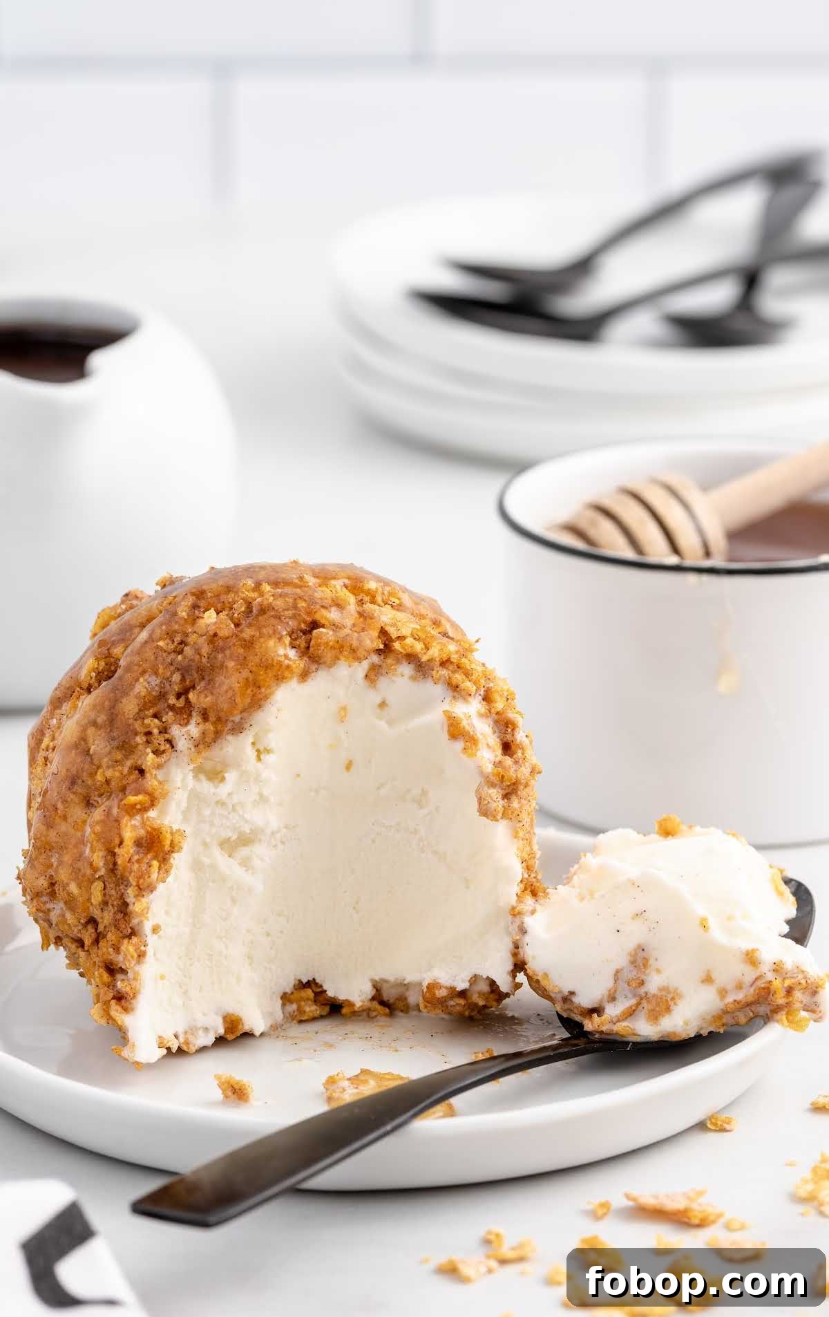 Authentic Mexican Fried Ice Cream Recipe: Crispy Cinnamon Sundae 10 a close up shot of Mexican Ice Cream on a plate with a piece taken out