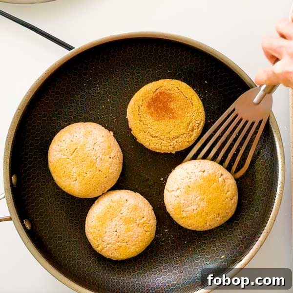 Flipping English muffins over in a skillet.