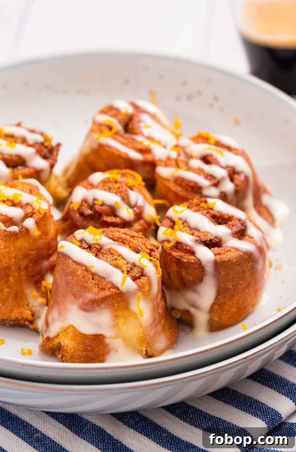 Low carb air fryer cinnamon rolls with a cream cheese glaze on a white plate.