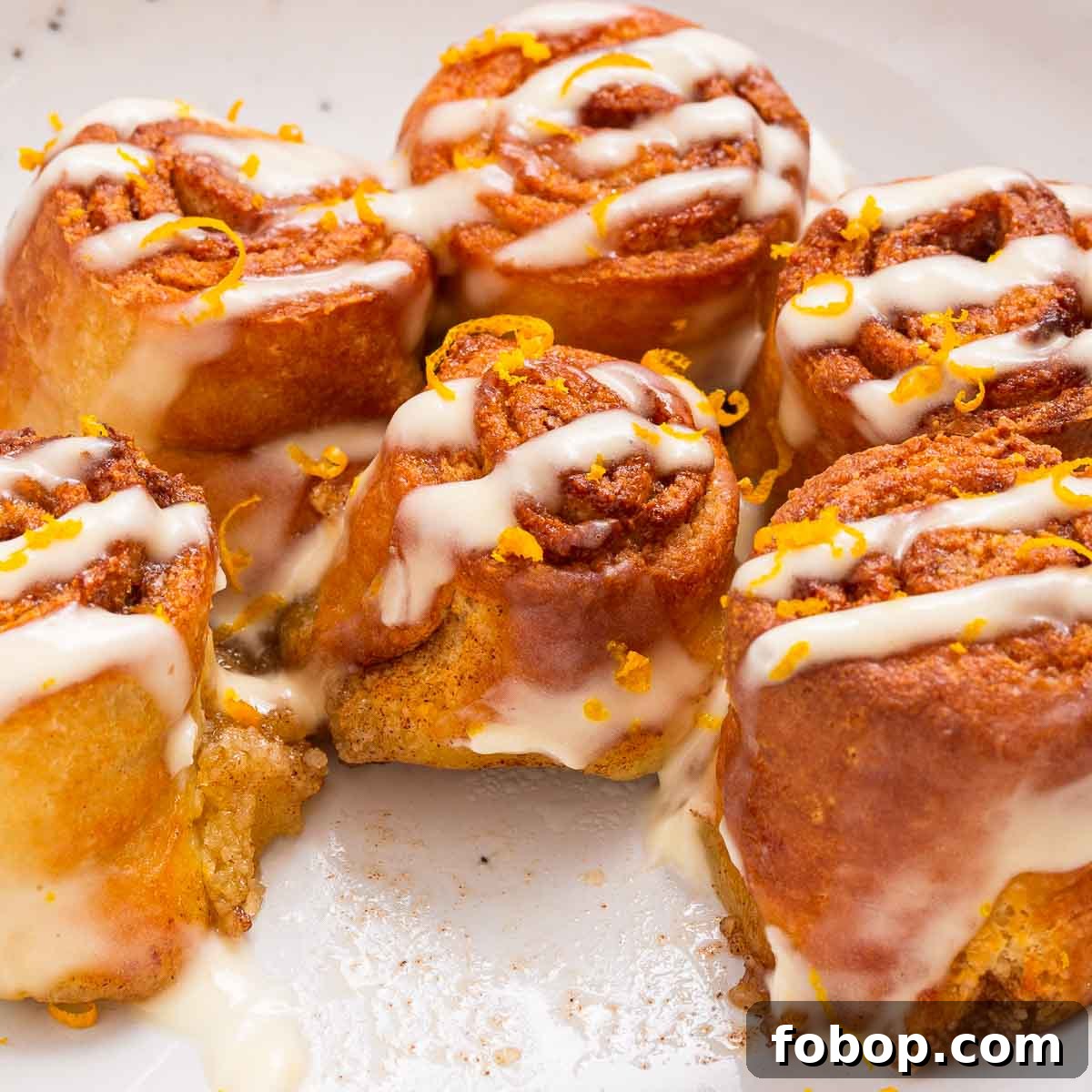 Low carb air fryer cinnamon rolls with a cream cheese glaze on a white plate