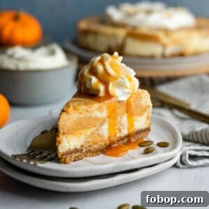 A slice of gluten-free pumpkin swirl cheesecake on a small plate topped with whipped cream and drizzled with caramel sauce.