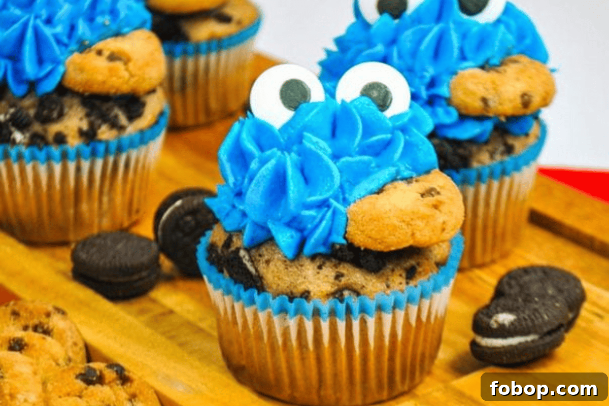 Cookie Monster Cupcakes: Fun Blue Cookie Dough Cupcake Recipe 11 4 cookie monster cupcakes eating with candy eyes and a chocolate chip cookie in their mouths.