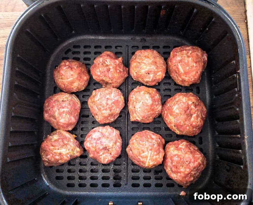 Crispy Air Fryer Meatballs in 10 Minutes: Quick Family Recipe 4 Meatballs in Air Fryer Basket ready to cook.