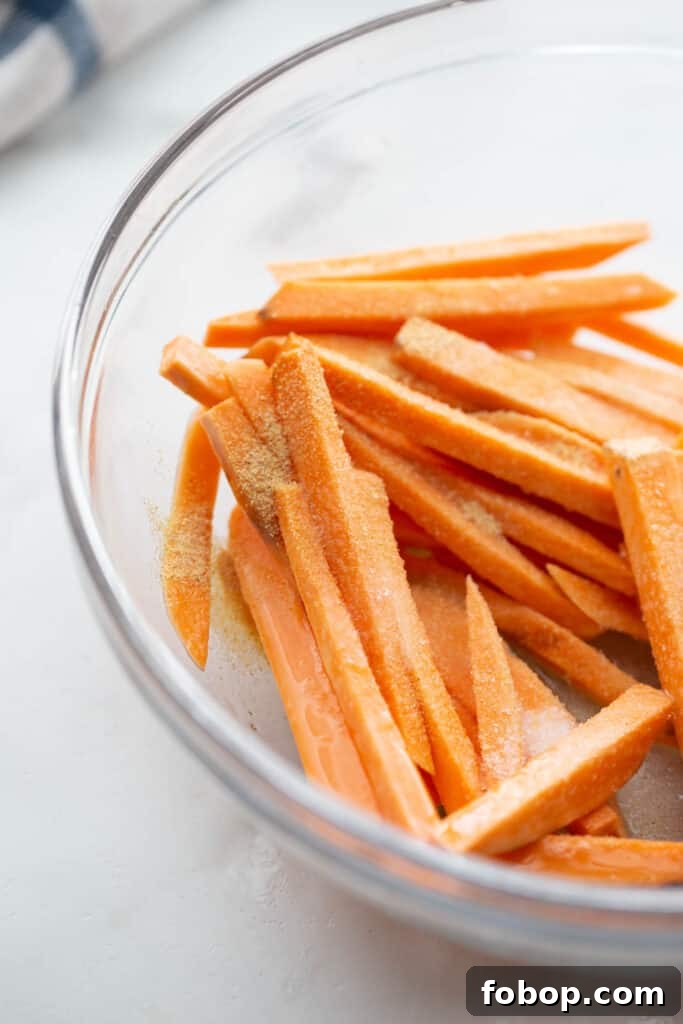 Crispy Air Fryer Sweet Potato Fries Recipe 7 A bowl of sweet potato fries tossed with egg whites and seasonings.