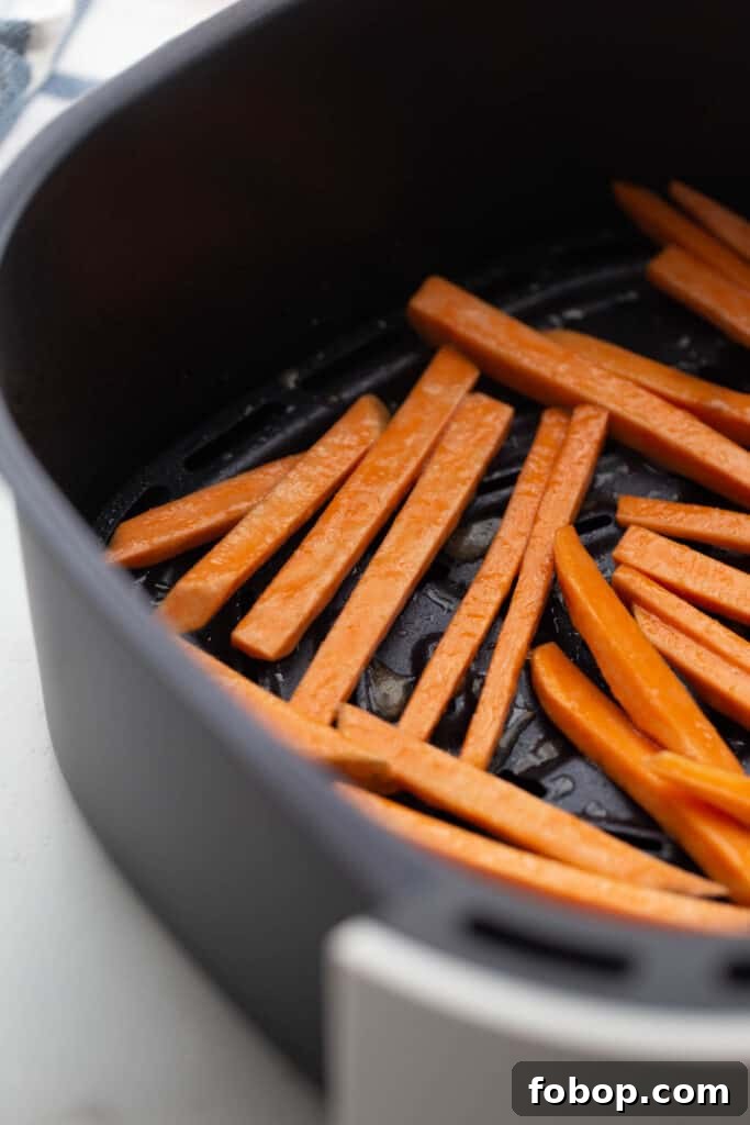 Crispy Air Fryer Sweet Potato Fries Recipe 8 Homemade Sweet Potato Fries in an air fryer basket.