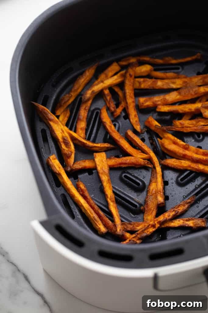 Crispy Air Fryer Sweet Potato Fries Recipe 9 An air fryer basket with hand cut sweet potatoes.