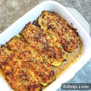A baking dish containing 4 cabbage-stuffed courgettes.