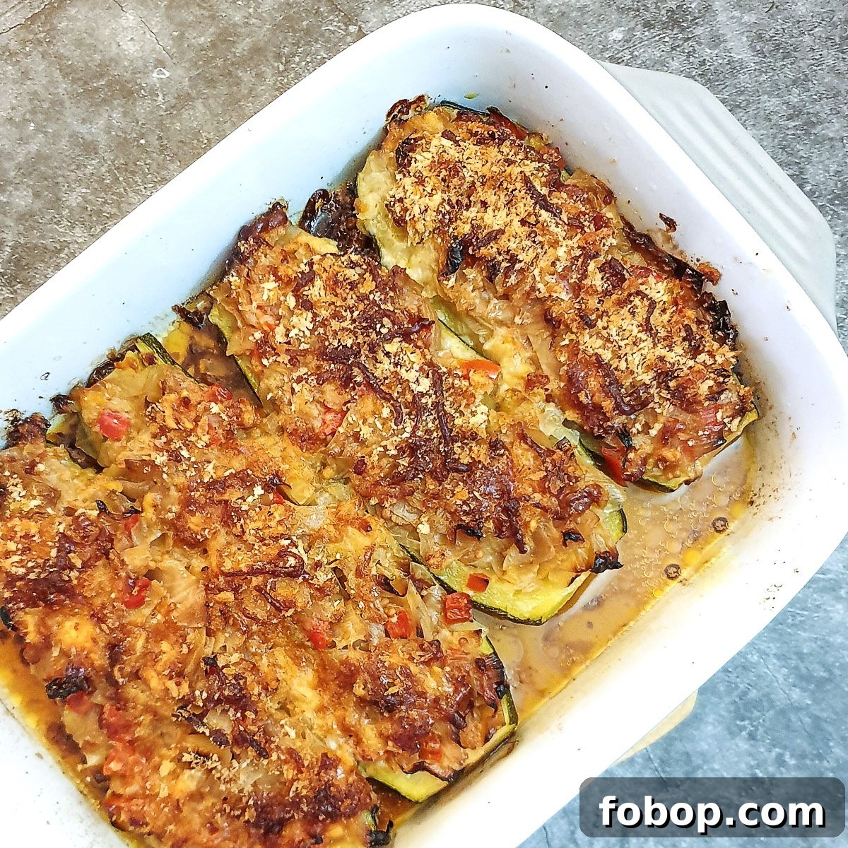 A baking dish containing 4 cabbage-stuffed courgettes.