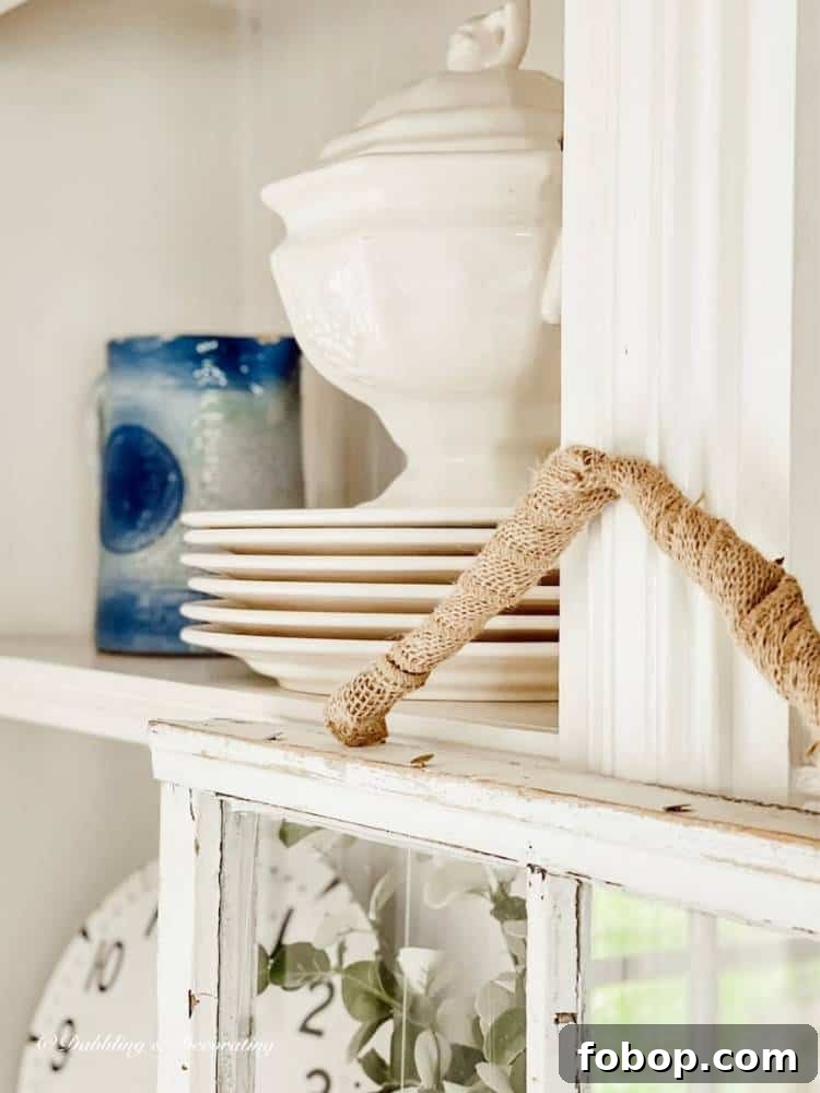 Stack of white ironstone dishes in a shelf with pottery.