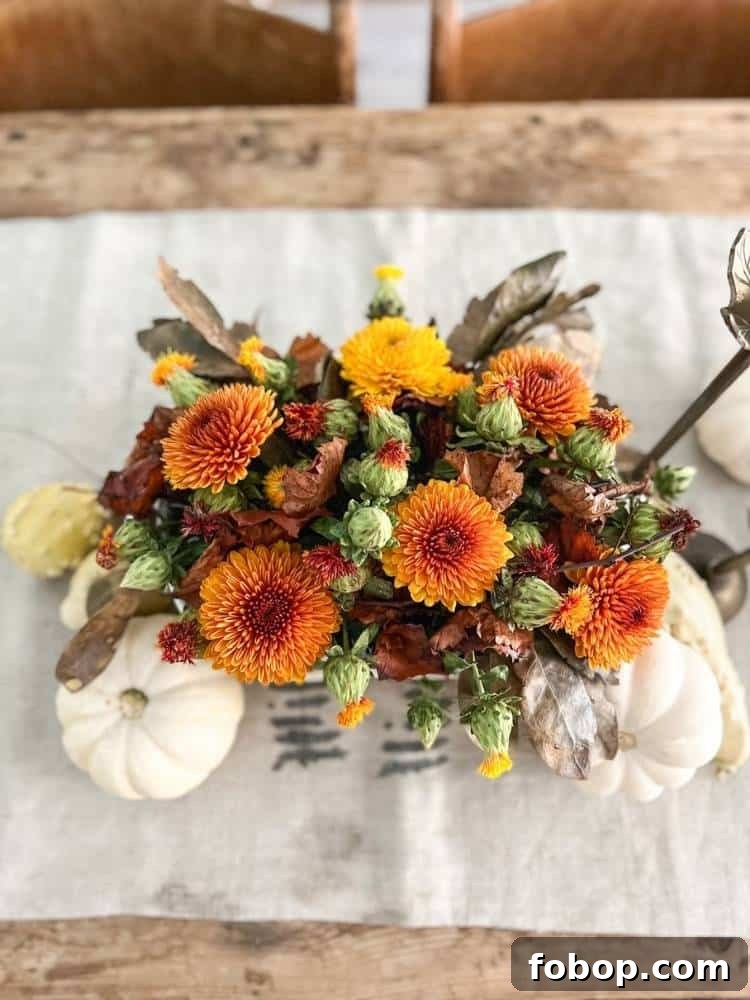 Overhead shot of a floral arrangement of mums and white pumpkins.