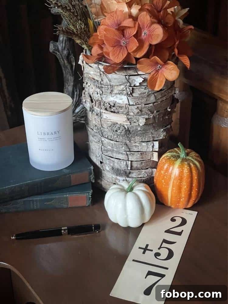 School desk with vase of hydrangeas, mini pumpkins, vintage books, and vintage flashcard.