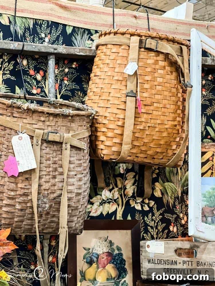 Antique picking baskets with harnesses hanging on the wall in an antique store.