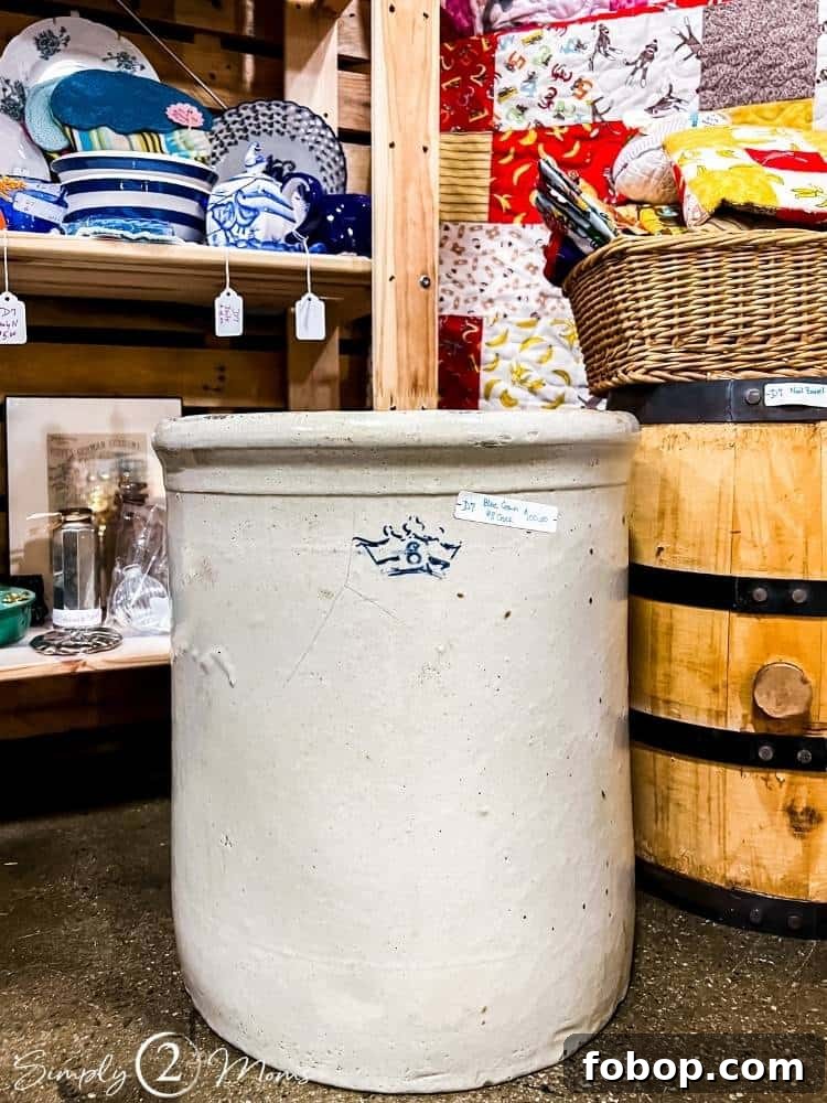 8 gallon vintage crock next to wood barrel in store