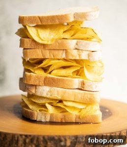 3 crisp sandwiches stacked on each other on wooden board
