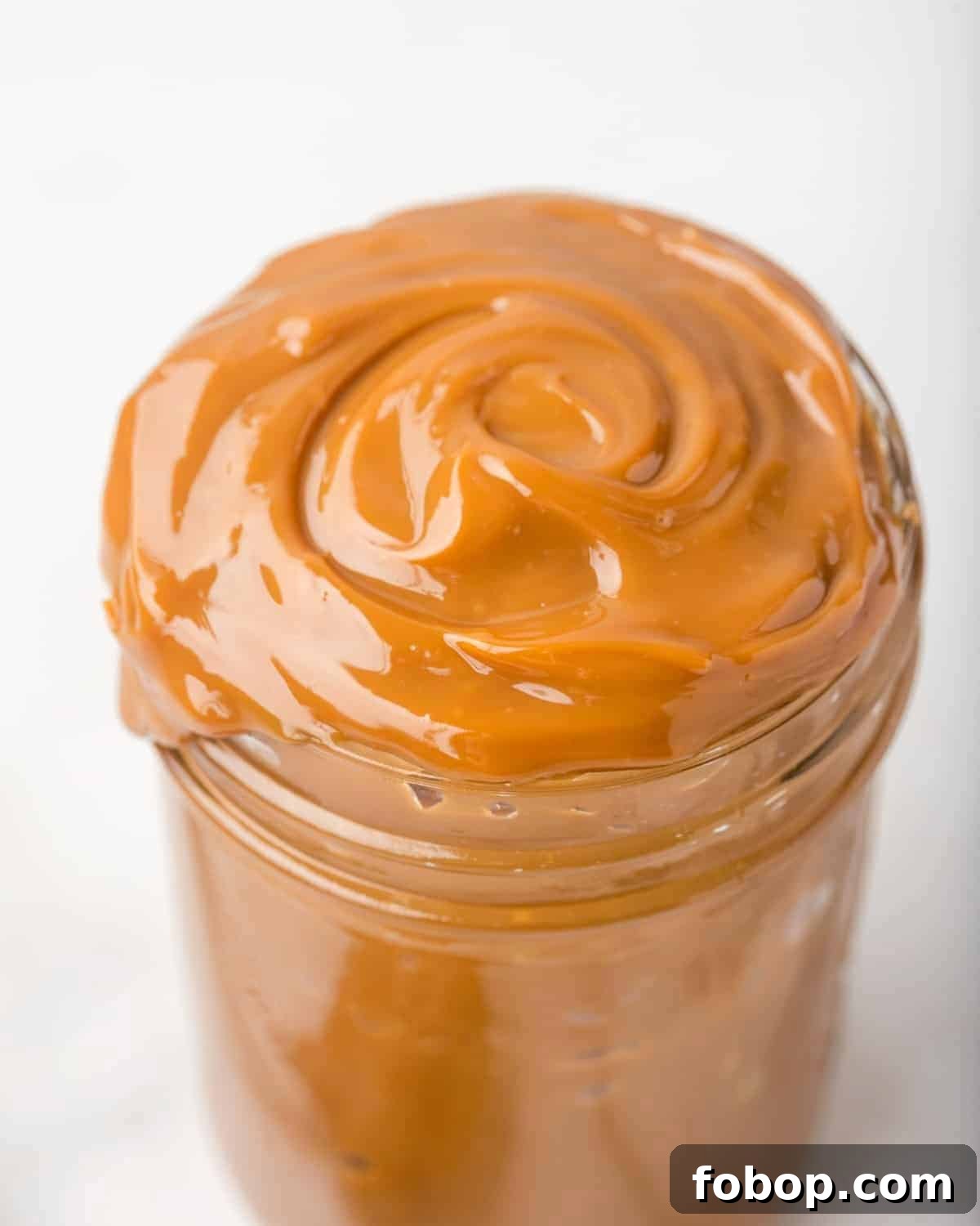 How to Make Creamy Homemade Dulce de Leche Quickly 2 homemade dulce de leche in a glass jar.