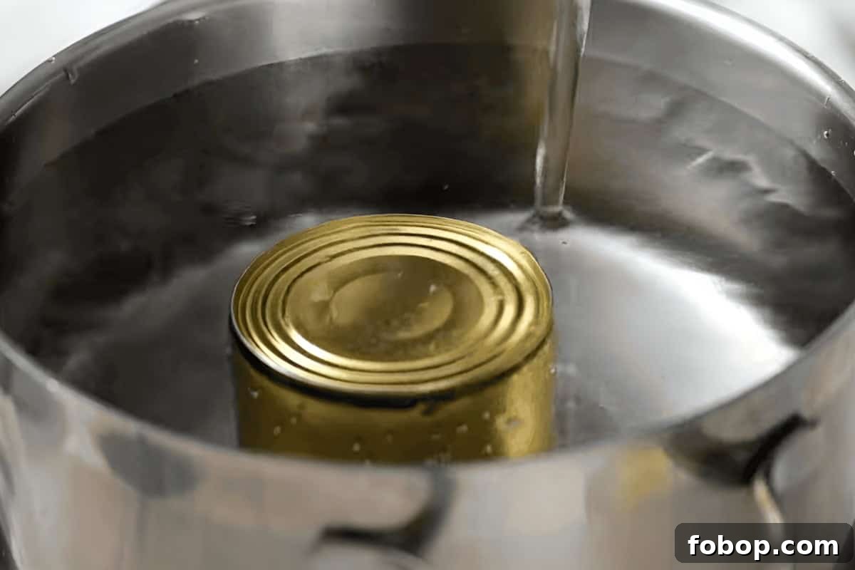 How to Make Creamy Homemade Dulce de Leche Quickly 8 pouring water over a can of sweetened condensed milk in a pot.