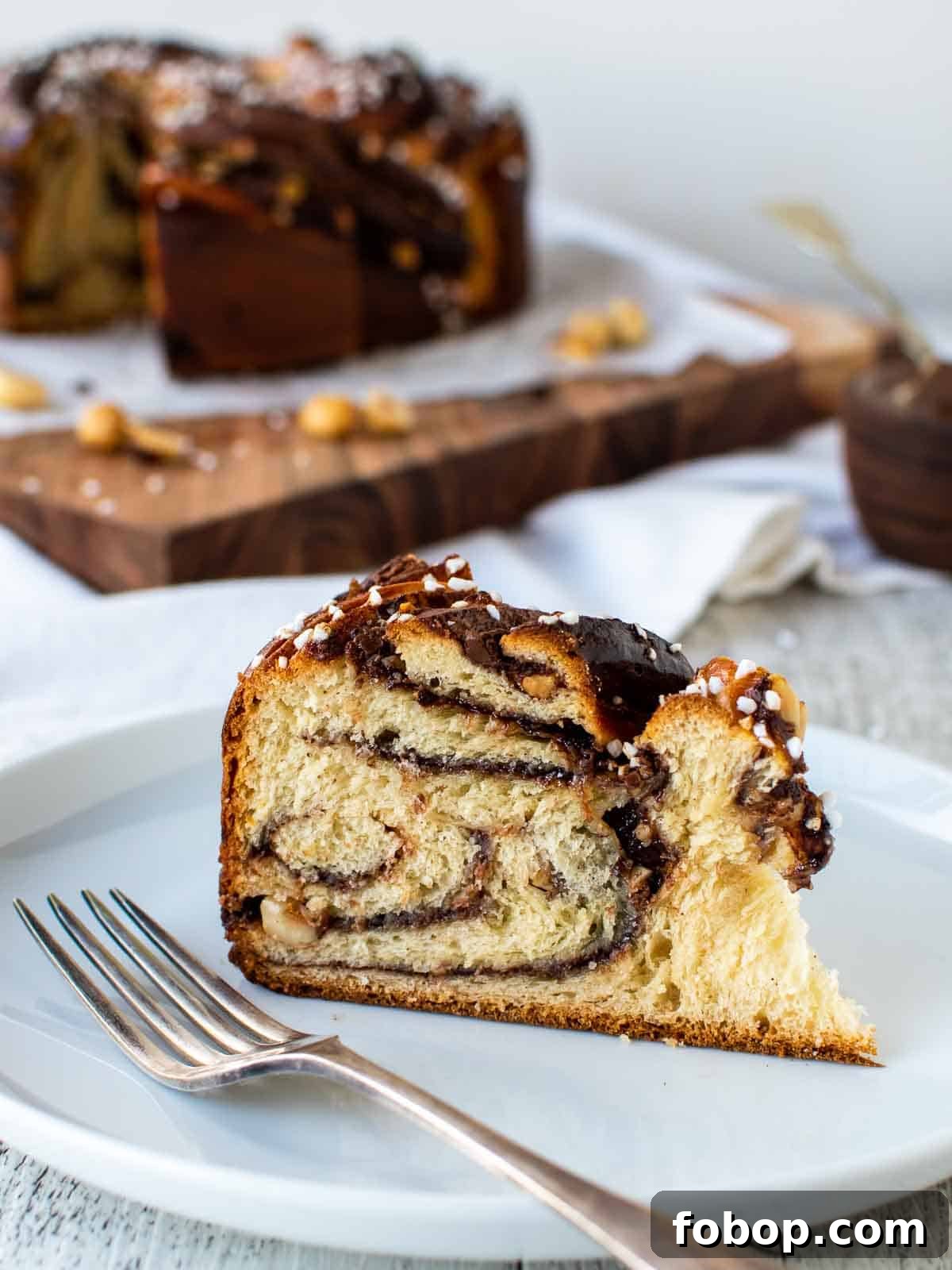 Wedge of nutella bread with swirls of chocolate inside on a white plate.