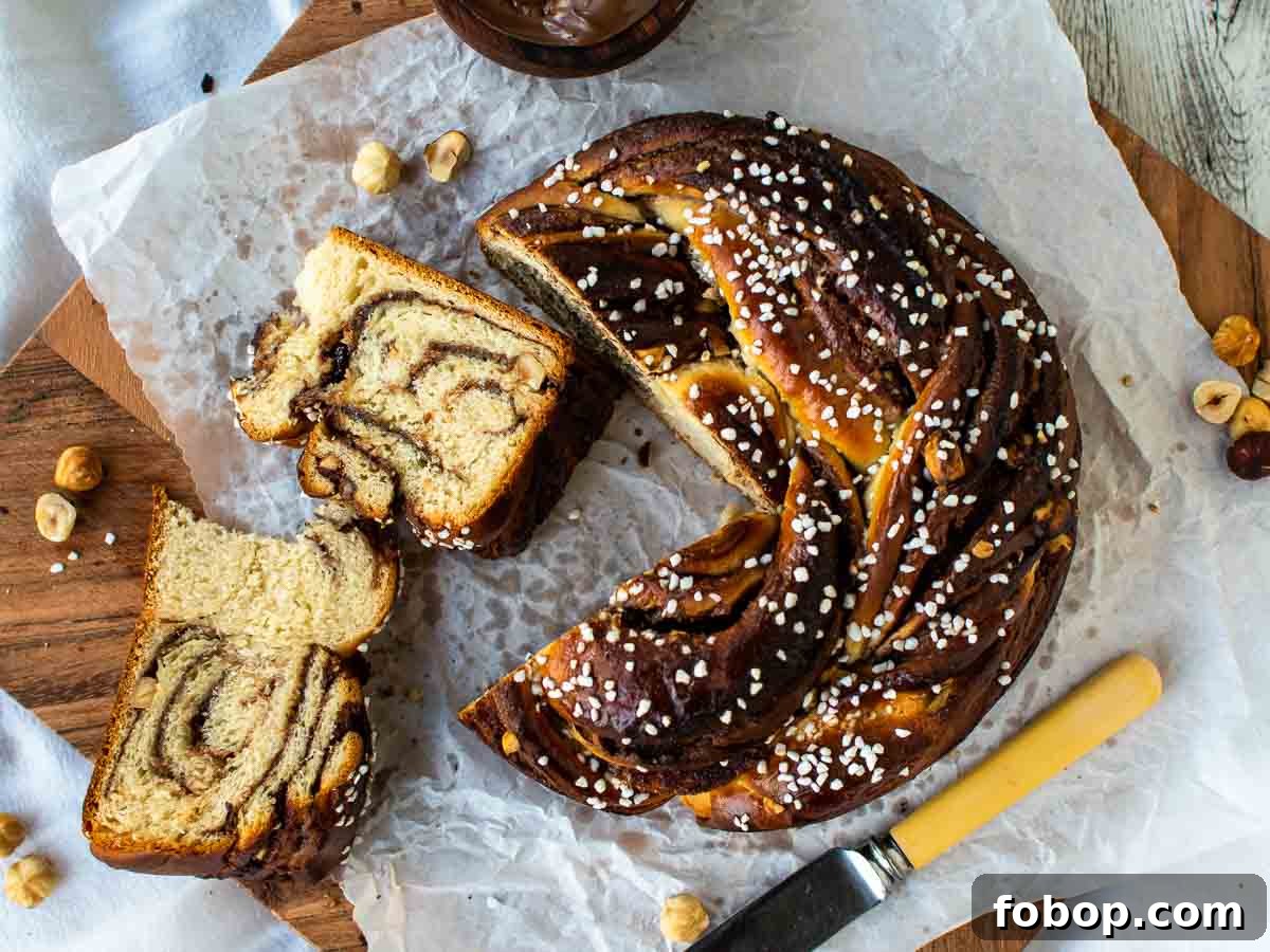 Overhead view of dark brown, round sweet bread with two slices cut, showing chocolate swirls inside,