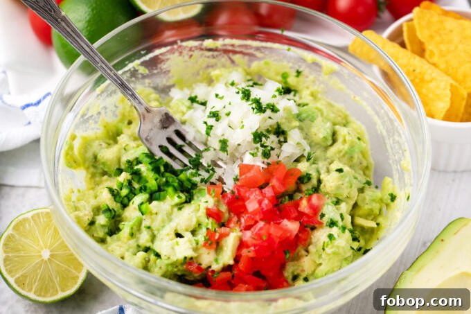 Mixing parsley, onion, tomatoes, and jalapenos in guacamole.