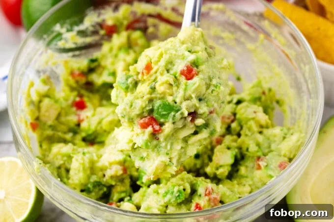 A serving spoon of chunky guacamole.