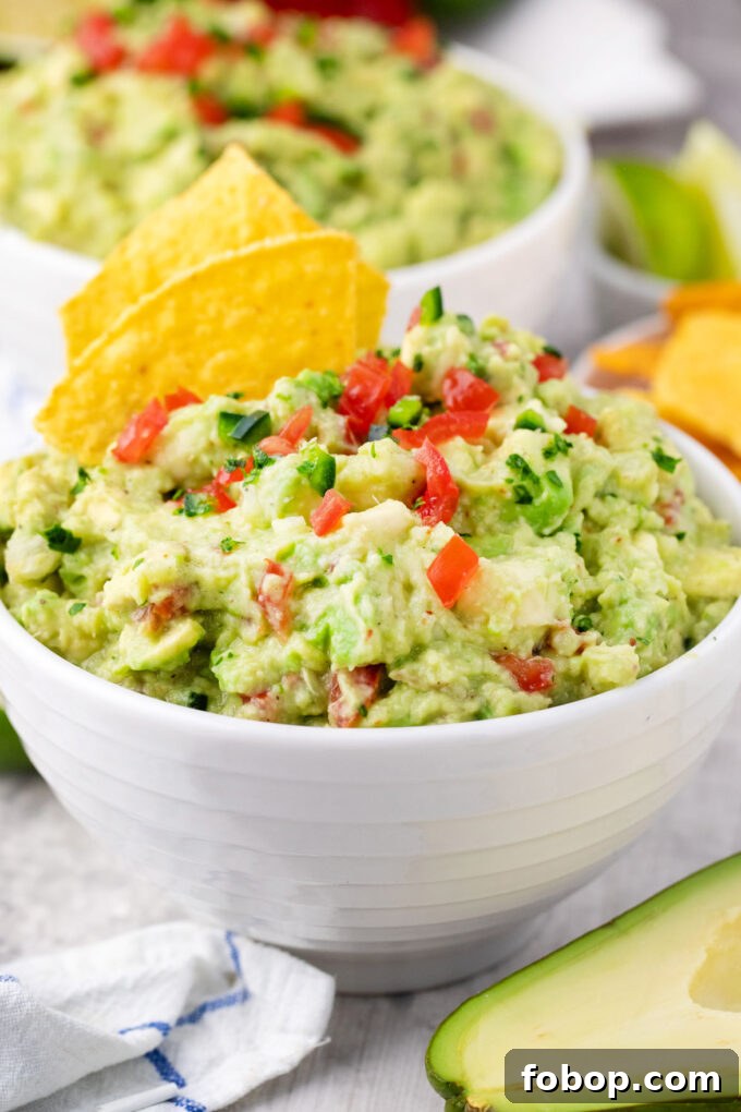 A bowl of Mexican guacamole with corn chips.