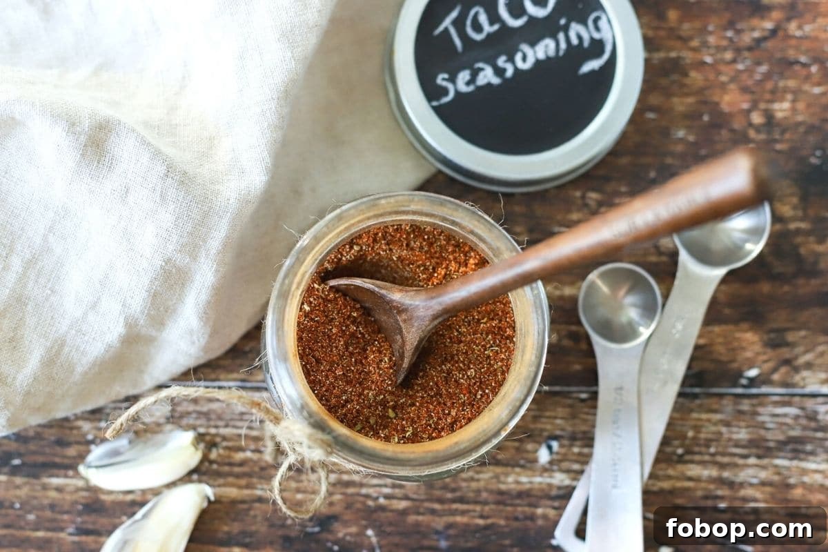 Homemade Mild Taco Seasoning Recipe for Authentic Flavor 2 jar of taco seasoning with a spoon out of it.