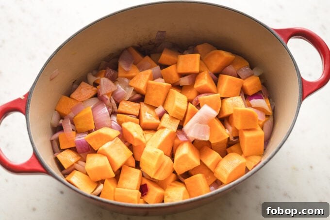Sweet Potato and Black Bean Chili Recipe for Cozy Weeknights 4 Dutch oven filled with diced sweet potato and red onion.