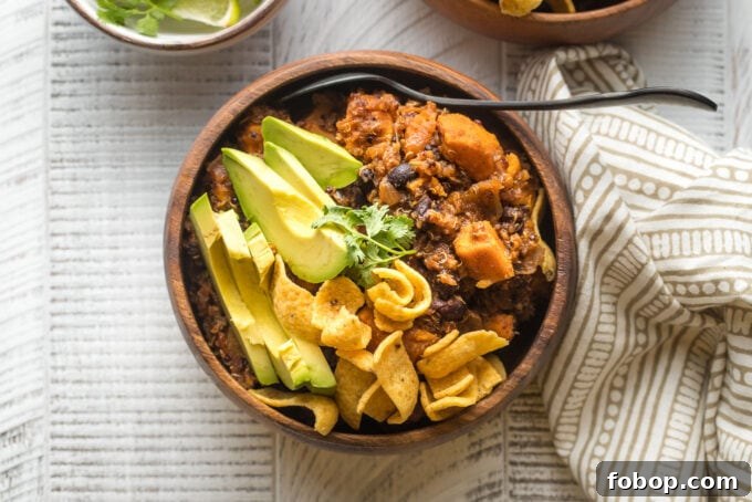Sweet Potato and Black Bean Chili Recipe for Cozy Weeknights 8 Bowl of sweet potato black bean chili served with avocado, cilantro, and corn chips.