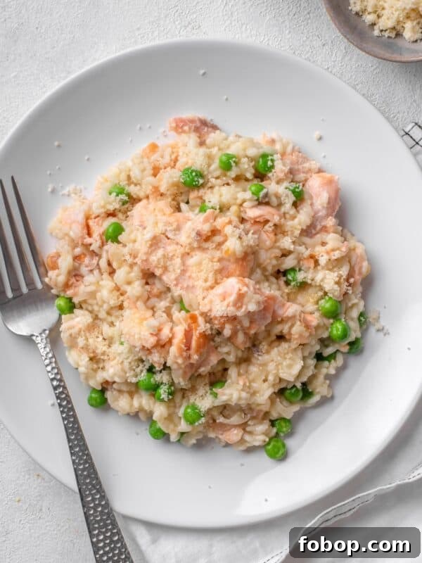 salmon risotto with peas served on a white plate.