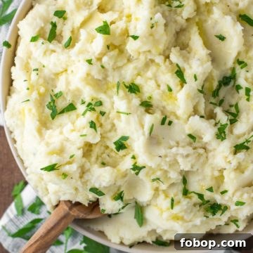Spoon dipped in bowl of truffle mashed potatoes.