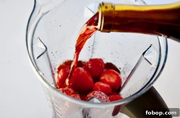 Frozen Sangria Recipe: Refreshing Frozen Sangria for Parties 4 Wine being poured into blender with frozen strawberries