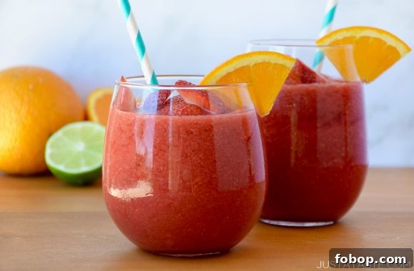 Frozen Sangria Recipe: Refreshing Frozen Sangria for Parties 5 Two wine glasses with The Best Frozen Sangria served with an orange garnish