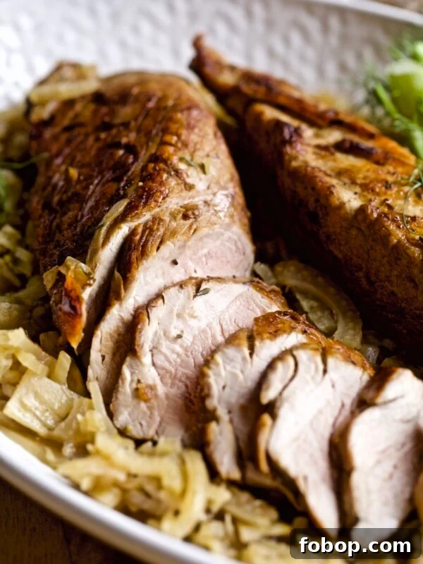 Tray with a partially-sliced pork tenderloin with fennel.