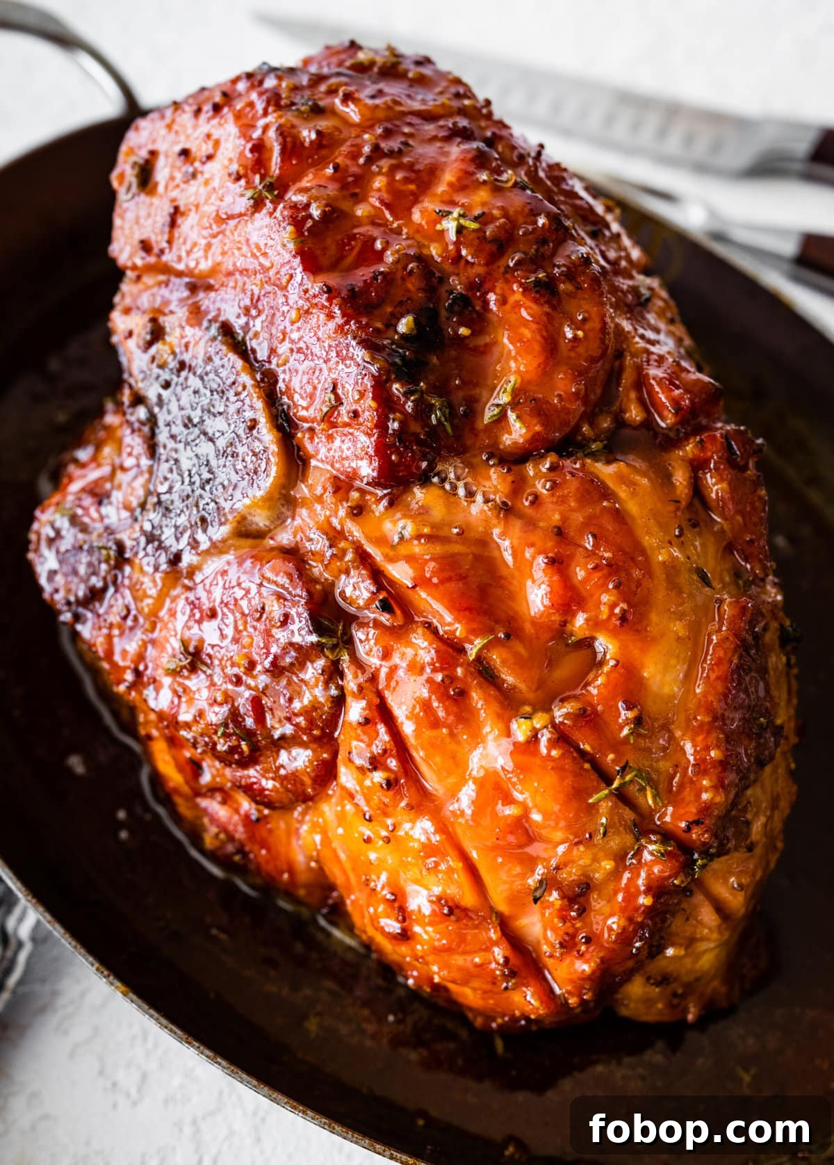 Perfectly baked ham with brown sugar glaze in a large baking dish.