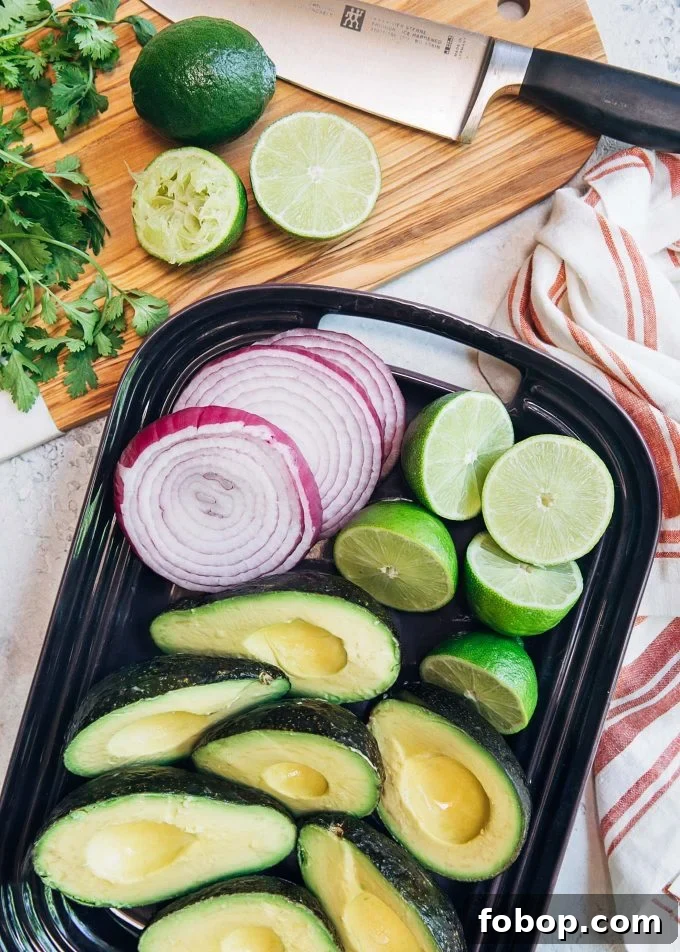 Smoky Grilled Avocado Guacamole Recipe for Backyard BBQs 3 avocados, onions, and limes on a platter for grilled guacamole