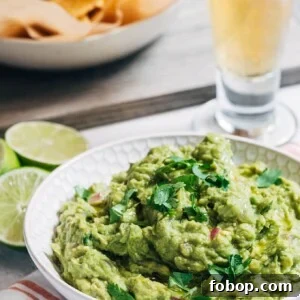 Smoky Grilled Avocado Guacamole Recipe for Backyard BBQs 6 grilled guacamole in a serving bowl with a dish of tortilla chips