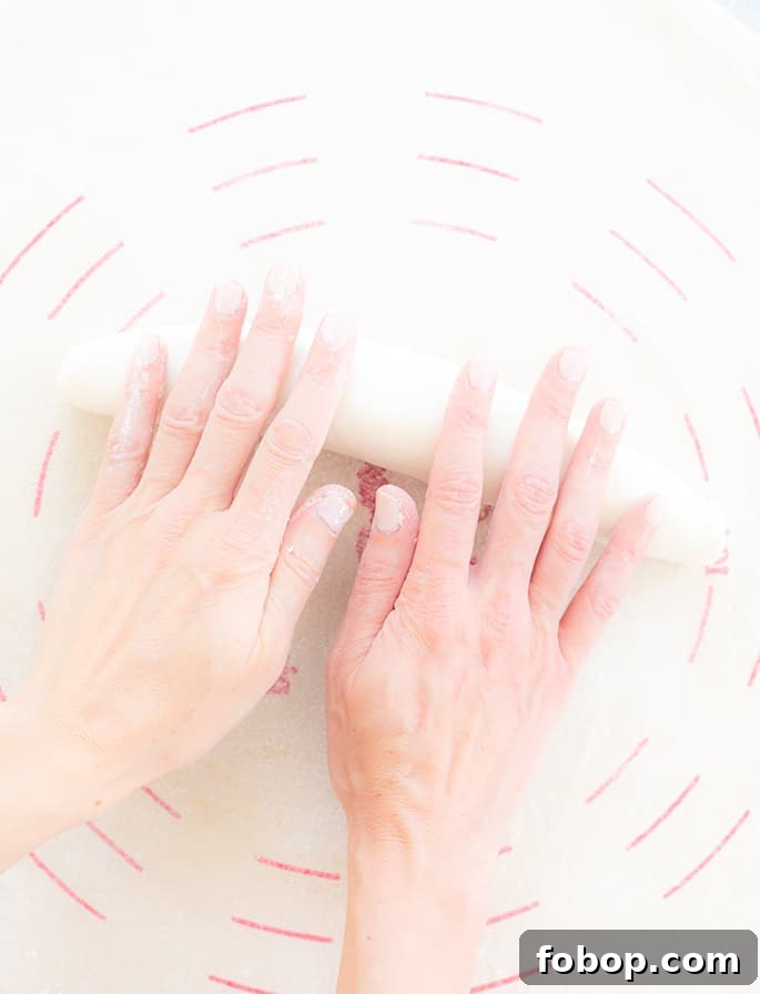 Crispy Gluten-Free French Baguettes: Artisan-Style Recipe 4 Two hands shaping a loaf of raw french bread dough on a canvas cloth with red lines